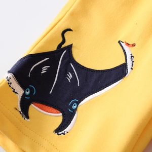 Macro view of high-quality yellow cotton fabric with stingray cartoon embroidery detail