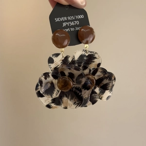 Detailed macro of resin flower earrings featuring leopard print petals and 925 silver needle