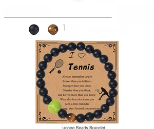 Détail de perles d'onyx noir mat 8mm et breloque tennis sur une carte cadeau