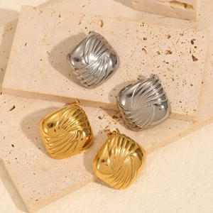 Pair of geometric vortex titanium steel earrings in gold and silver finish on stone