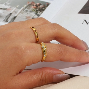 Detail of gold plated stainless steel rings featuring hollow star and wavy zircon designs