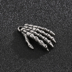 Macro detail of vintage silver stainless steel skull hand charm with aged metal texture
