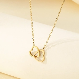 Close-up of dual interlocking golden heart pendants on a delicate 18K plated stainless chain