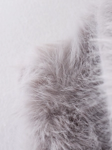 Dettaglio del tessuto in peluche grigio chiaro a pelo lungo con fibre morbide e lisce