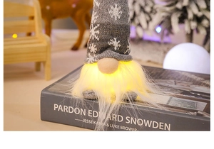 Close-up of glowing forest gnome with grey snowflake knit hat on Christmas book decor