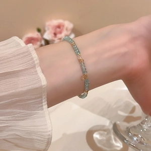 Detail of light blue geometric crystal beaded bracelet on wrist with elegant soft lighting