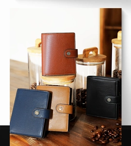 Close-up of RFID leather wallets in four colors on a vintage wooden desk with coffee beans