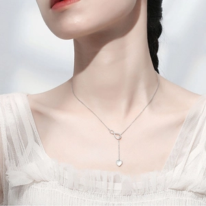 Minimalist Y-shaped necklace with silver infinity symbol and heart pendant on a model