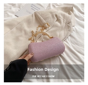 Close-up of pink sequin clutch bag with golden arched handle and pearl clasp detail