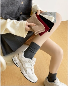 Close-up of ribbed combed cotton socks in multiple colors on a warm wooden floor