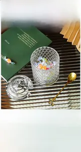 Detail of European honeycomb glass jar with golden leaf spoon for sugar or jewelry storage