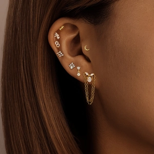 Macro detail of 925 silver gold tassel earring with cubic zirconia on female ear
