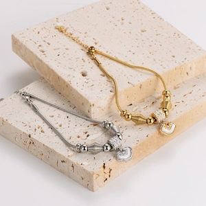 Snake chain bracelet with shell cloud pendant and polished beads in gold and silver