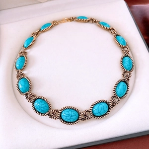 Close-up of vintage style necklace with turquoise stones in a white jewelry box
