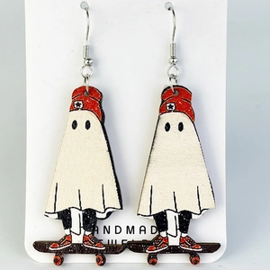 Detail of handmade wooden earrings featuring cute ghosts on red skateboards