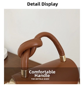 Close-up of the knotted brown leather handle and gold hardware on a straw bag
