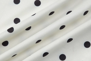 Detailed view of the soft fabric featuring classic white and black polka dot pattern