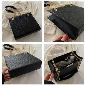 Detail view of black quilted crossbody bag with gold chain and spacious interior