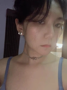Detailed selfie showing silver chain necklace and crystal stud earrings on model