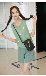 Detailed view of black PU leather crossbody bag with crown embossing and gold tassel