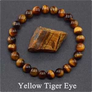 8mm natural yellow tiger eye beaded bracelet with matching raw gemstone on dark background