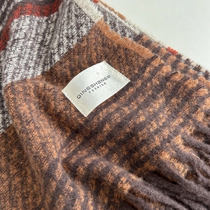 Thick checkered scarf in brown and orange tones with fringes and fashion brand label
