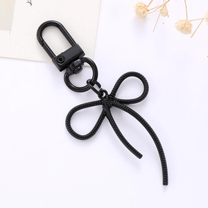 Détail du porte-clés élégant en forme de nœud papillon en métal noir au design épuré