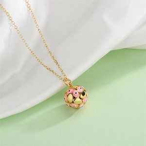 Macro shot of gold necklace with a pink enamel sphere pendant featuring evil eye patterns