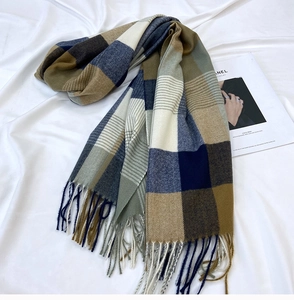 Detail of soft multi-color plaid scarf featuring classic fringe and thick warm texture