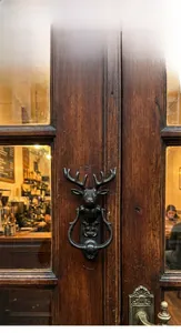 Détail d'un heurtoir de porte en fonte en forme de tête de cerf sur une porte en bois