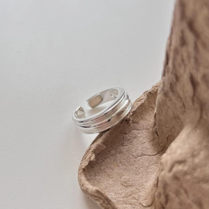Detailed view of minimalist S925 silver multi-layer open ring on brown textured paper