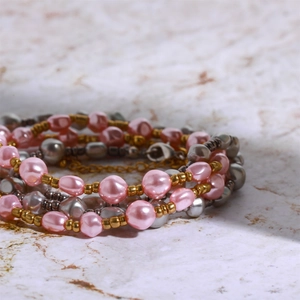Detailed close-up of multilayered baroque pearl and metallic bead bracelet on marble