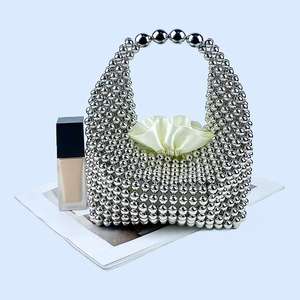 Detail of silver beaded weave pillow bag with cream silk drawstring liner and metallic finish