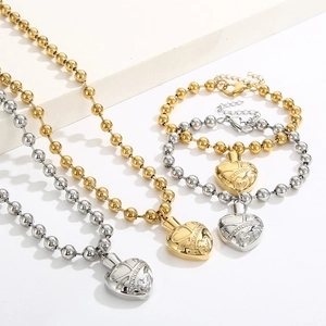 Detailed view of heart locket pendants on bead chain necklaces in gold and silver finish