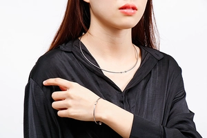 Detailed close-up of silver stainless steel choker and bracelet set with spherical ends