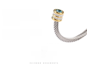 Detail of twisted cable cuff bracelet with blue center stone and pave zircon accents