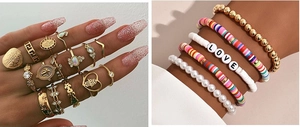Detailed close-up of bohemian gold layered bracelets with colorful beads and love letters