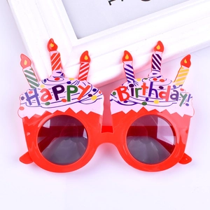 Detail of red cake-shaped birthday party glasses with colorful candles and Happy Birthday text