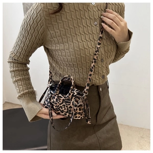 Primo piano del mini secchiello leopardato con chiusura a coulisse e tracolla sottile