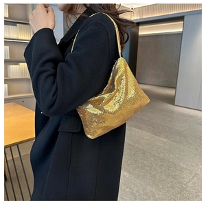 Détail de la texture pailletée dorée et de la maille souple du sac porté épaule
