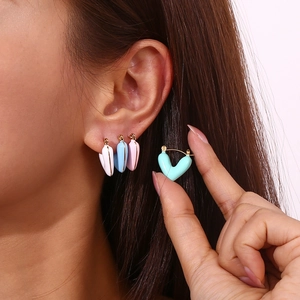 Macro shot of 18K gold plated heart enamel earrings in various pastel macaron colors