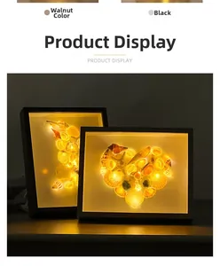 Detail of LED seashell shadow box with heart and moon patterns in walnut and black frames