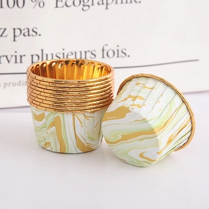 Detail of green marble paper muffin cups with golden rolled edges and oil-proof lining