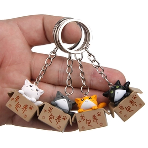 Close-up of four cute 3D cartoon cats in miniature cardboard boxes as keychains