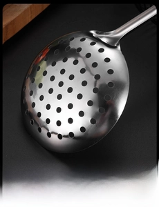 Detailed close-up of a stainless steel skimmer spoon with uniform hollowed-out holes
