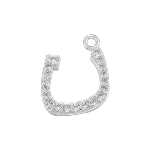 Macro shot of horseshoe-shaped silver pendant with micro-set zircons and top jump ring