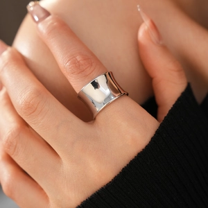 Detail shot of wide silver concave ring showing high polish finish on human finger