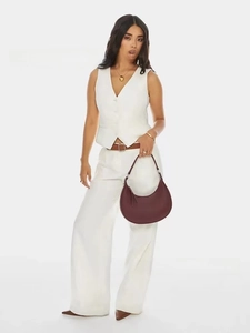Detail view of burgundy half-moon handbag with gold zipper and adjustable buckle strap