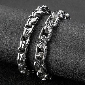 Close-up of vintage steel bracelets with floral engraving and geometric chain link details