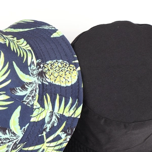 Detail of tropical pineapple print and solid black cotton twill bucket hats texture
